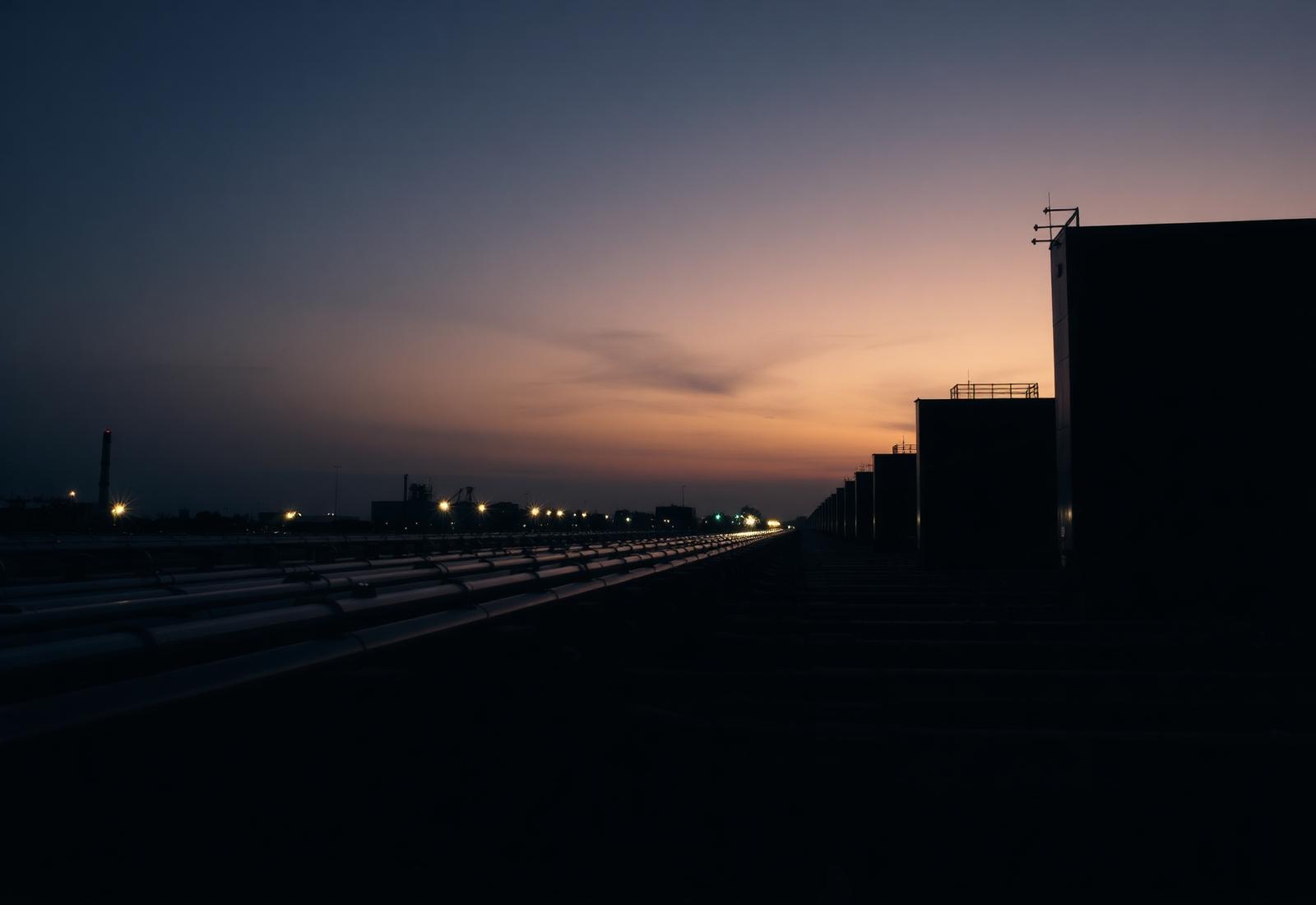 Industrial natural gas turbine pipework array at dusk.